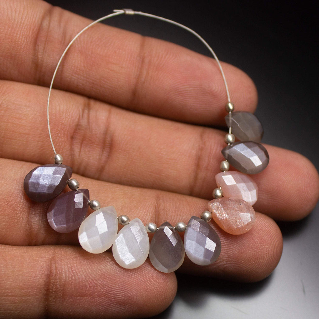 15 matching pairs of 10mm natural multi-color moonstone pear drop beads. Each bead has a faceted surface with a soft, glowing sheen, perfect for use in earrings, necklaces, or other custom jewelry projects, adding an elegant and colorful touch